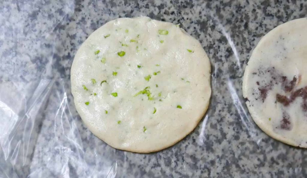 Uncooked pupusa placed on non stick film.