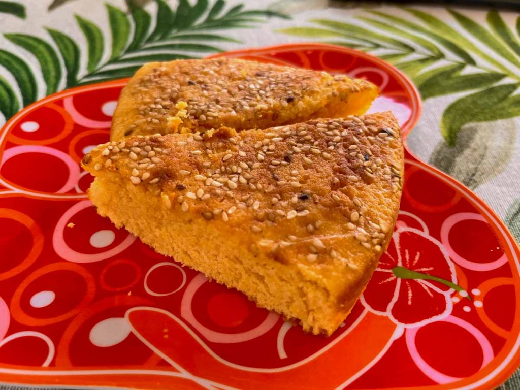 Salvadorian Quesadilla cake cut into triangles slices served on a plate.