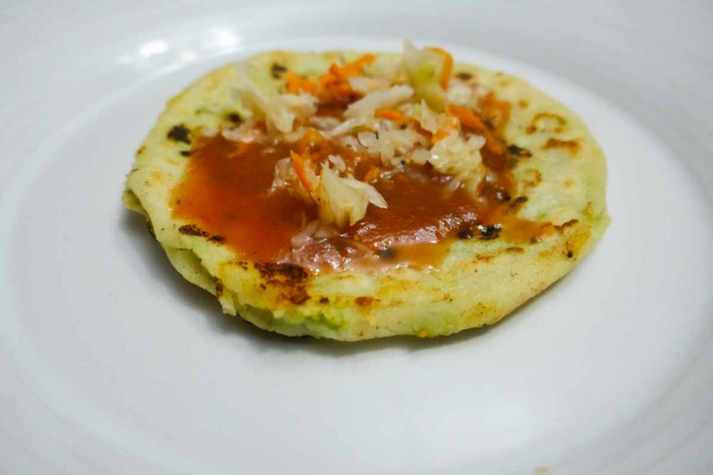 How El Salvador pupusas look with traditional toppings. Pupusa slaw is called curtido and the salsa for pupusas, salsa roja.