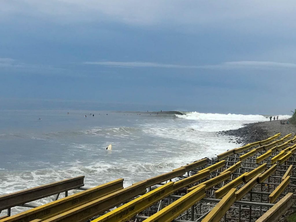 Surf Spot Punta Roca, El Salvador. Wave breaking on a point break with surfers in the water.
