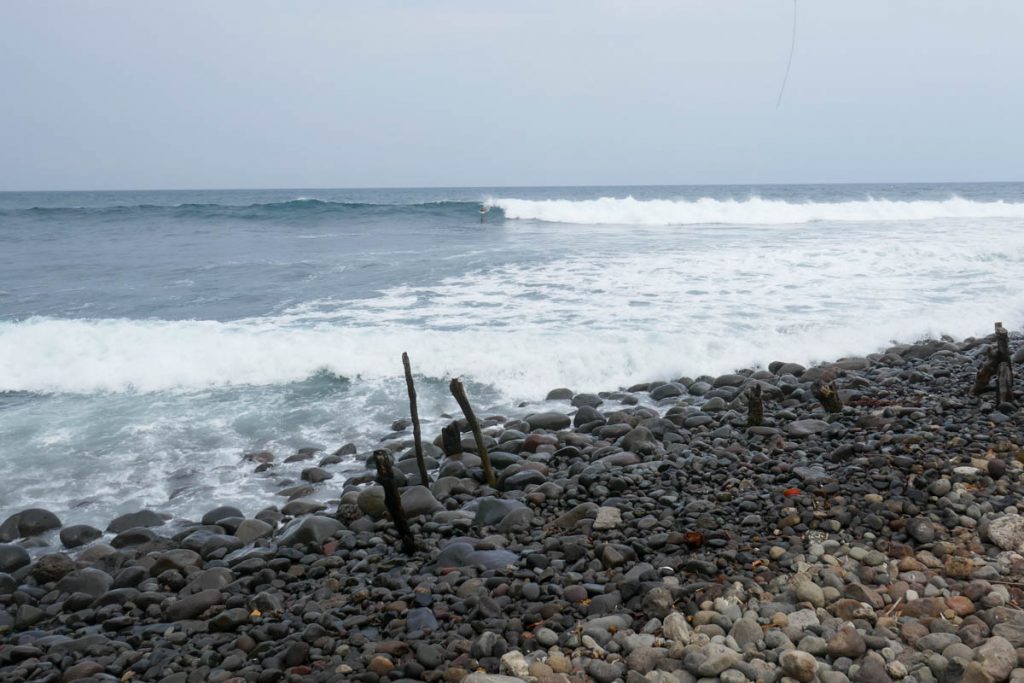 Surf spot El Zonte, El Salvador. Wave breaking with surfer catching the wave.